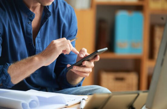 homem-de-camisa-azul-usa-aplicativo-de-loja-online-no-seu-smartphone-em-um-estoque