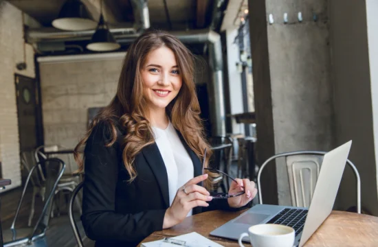 Jovem empresária sorrindo ao trabalhar em notebook