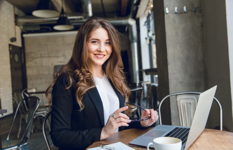 Jovem empresária sorrindo ao trabalhar em notebook